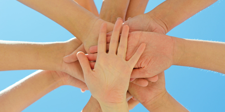 Mange hænder oven på hinanden. 